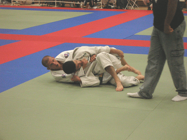 finnie mcmahon applying back choke to another practitioner in jiu-jitsu tournament 